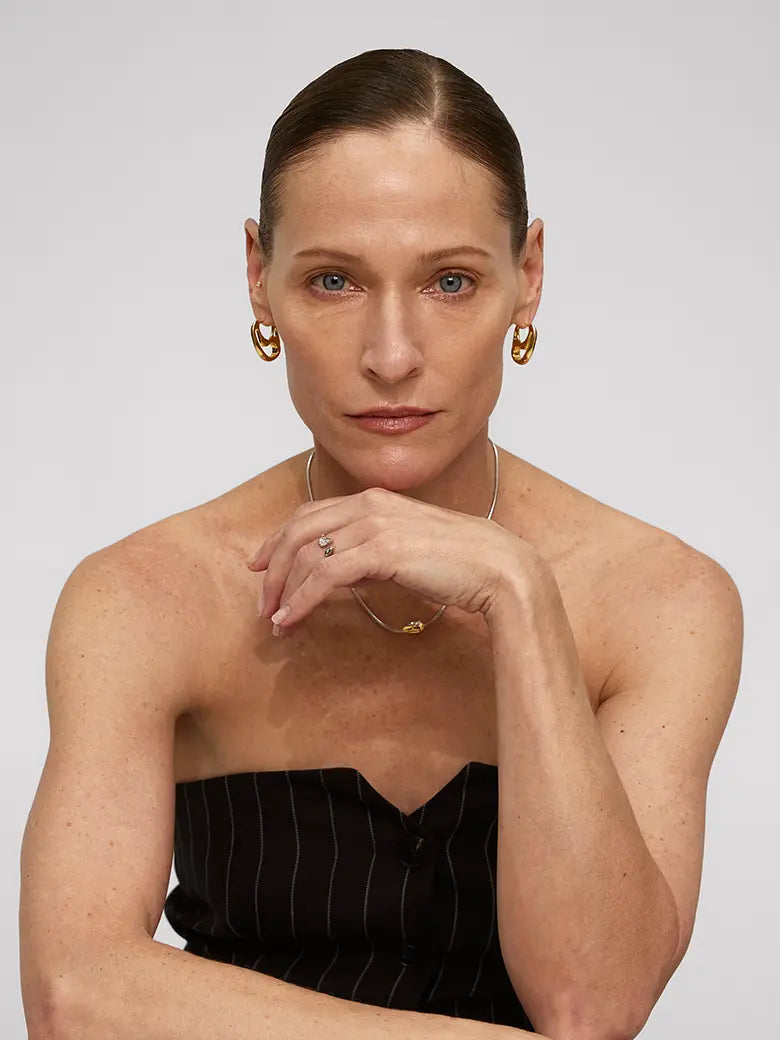 Woman modeling Contour Hoops Earrings, showcasing the sleek design and unique silhouette.