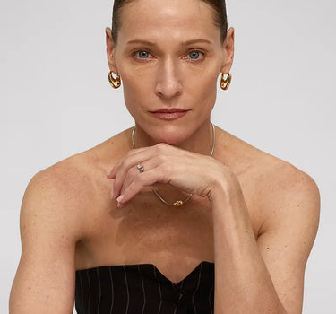 Woman modeling Contour Hoops Earrings, showcasing the sleek design and unique silhouette.