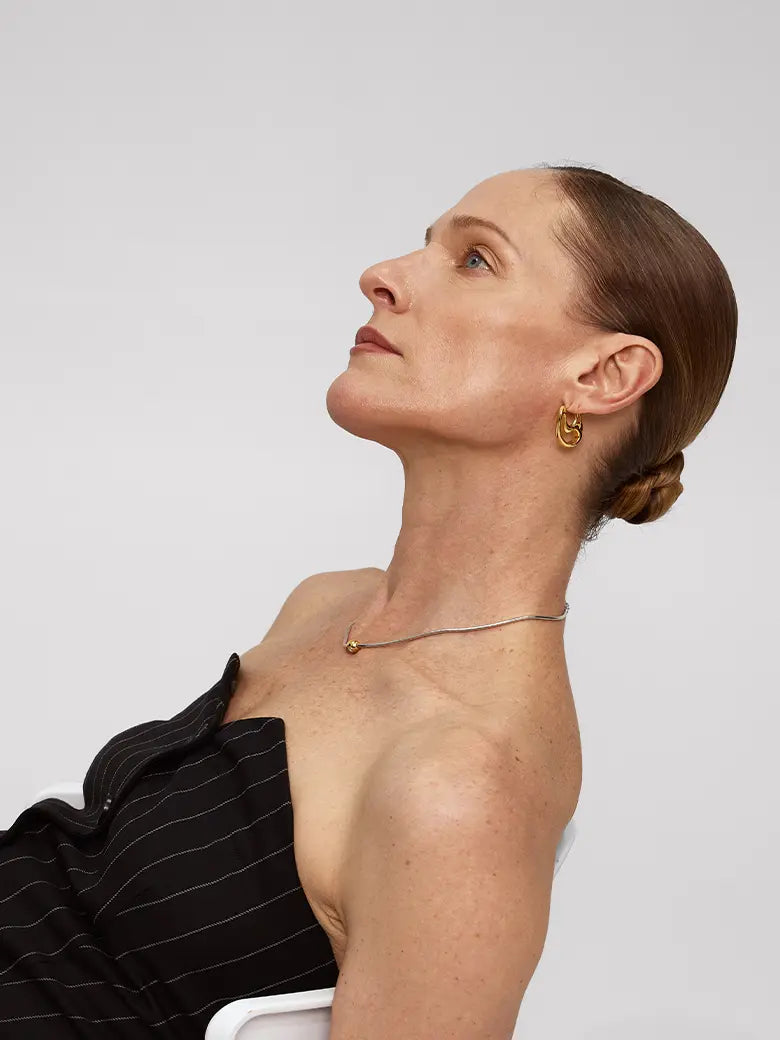 Model showcasing Contour Hoops Earrings with a sleek design and gentle curve, set against a neutral background.