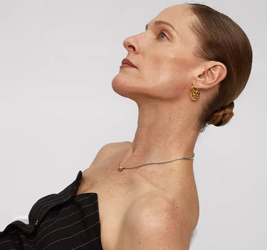Model showcasing Contour Hoops Earrings with a sleek design and gentle curve, set against a neutral background.