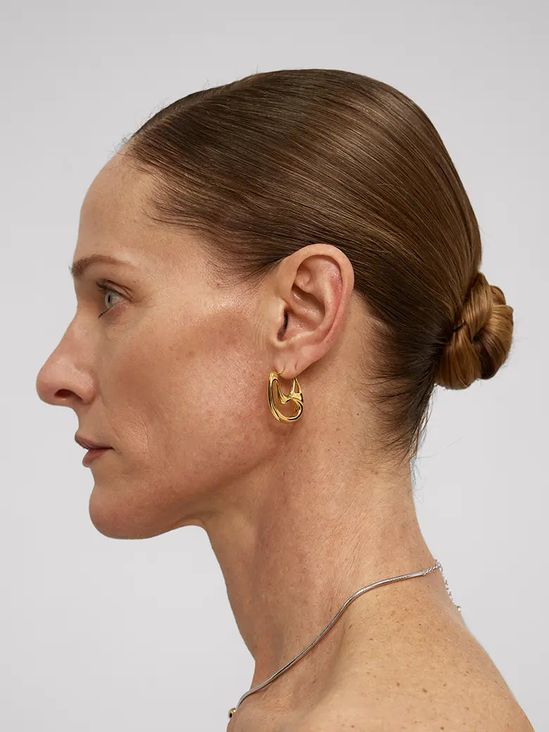 Profile view of a woman wearing Contour Hoops Earrings, showcasing their sleek and modern design.