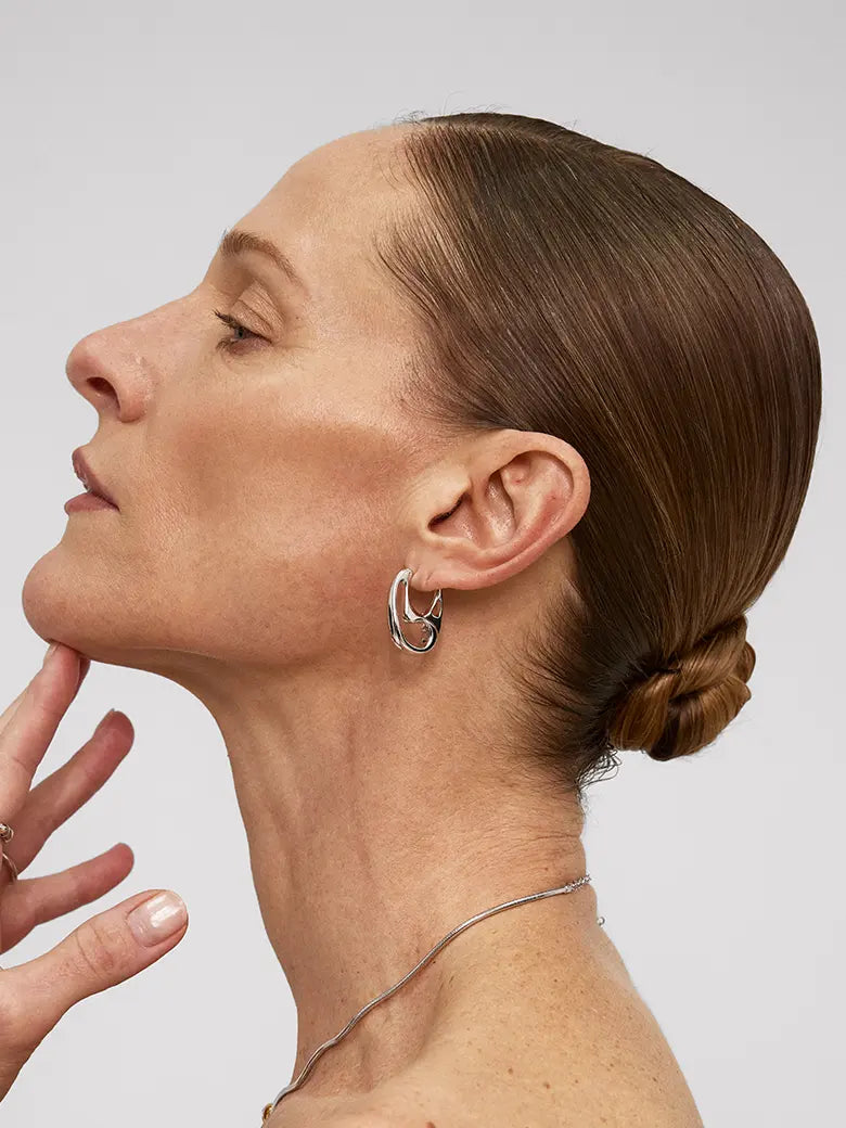 Woman wearing Contour Silver Hoops Earrings, showcasing minimalist sculptural design and organic elegance.