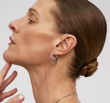Woman wearing Contour Silver Hoops Earrings, showcasing minimalist sculptural design and organic elegance.