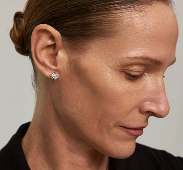 Model wearing Diamond Arc Silver Stud Earrings, showcasing elegant design and diamond accents in a close-up profile view.