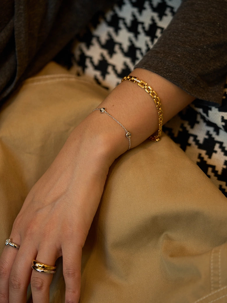 Diamond Bezel Dot Silver Bracelet worn alongside a gold chain bracelet on a woman's wrist.