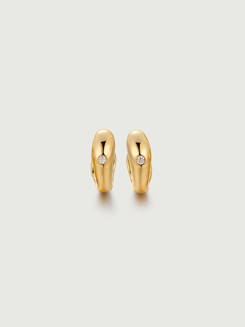 diamond dome hoop earrings in polished gold with diamond accents, showcasing their minimalist sculptural design.