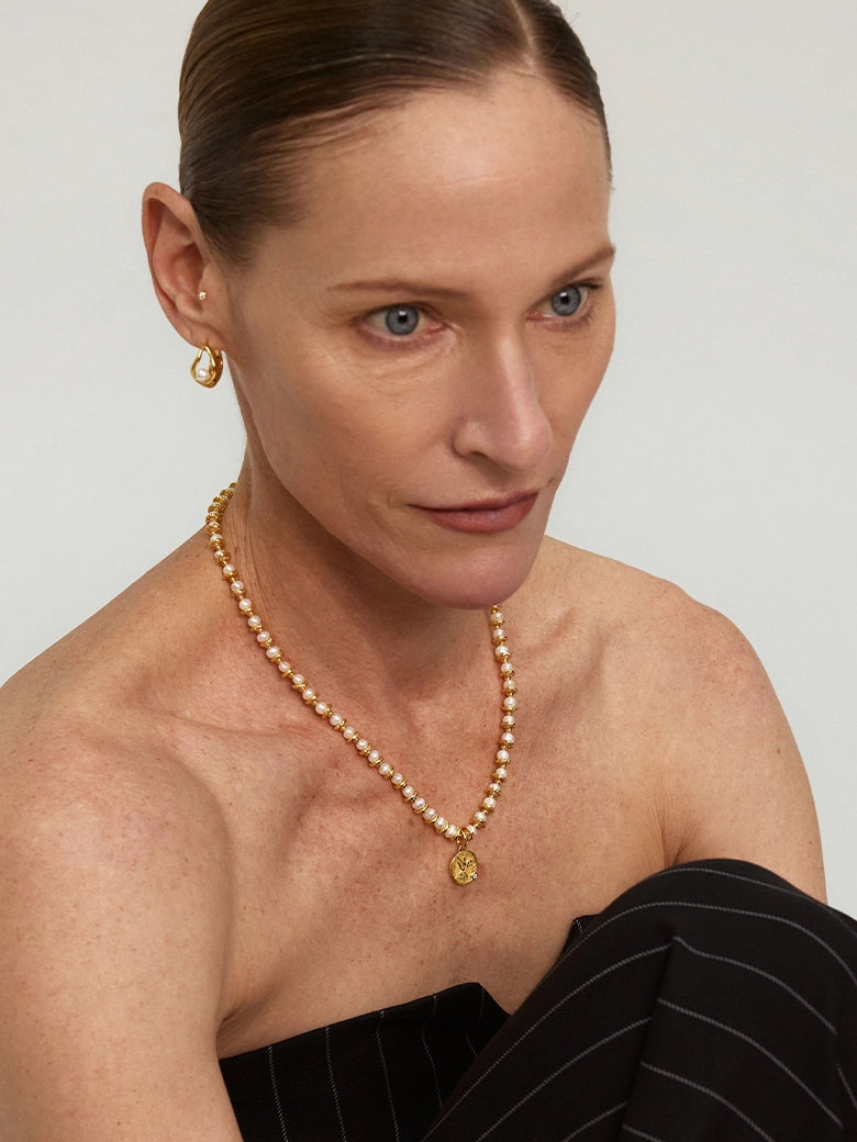 Close-up of a woman's neck showcasing Diamond Dove Coin Pearl Necklace