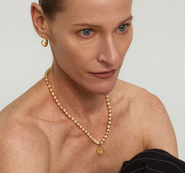Close-up of a woman's neck showcasing Diamond Dove Coin Pearl Necklace