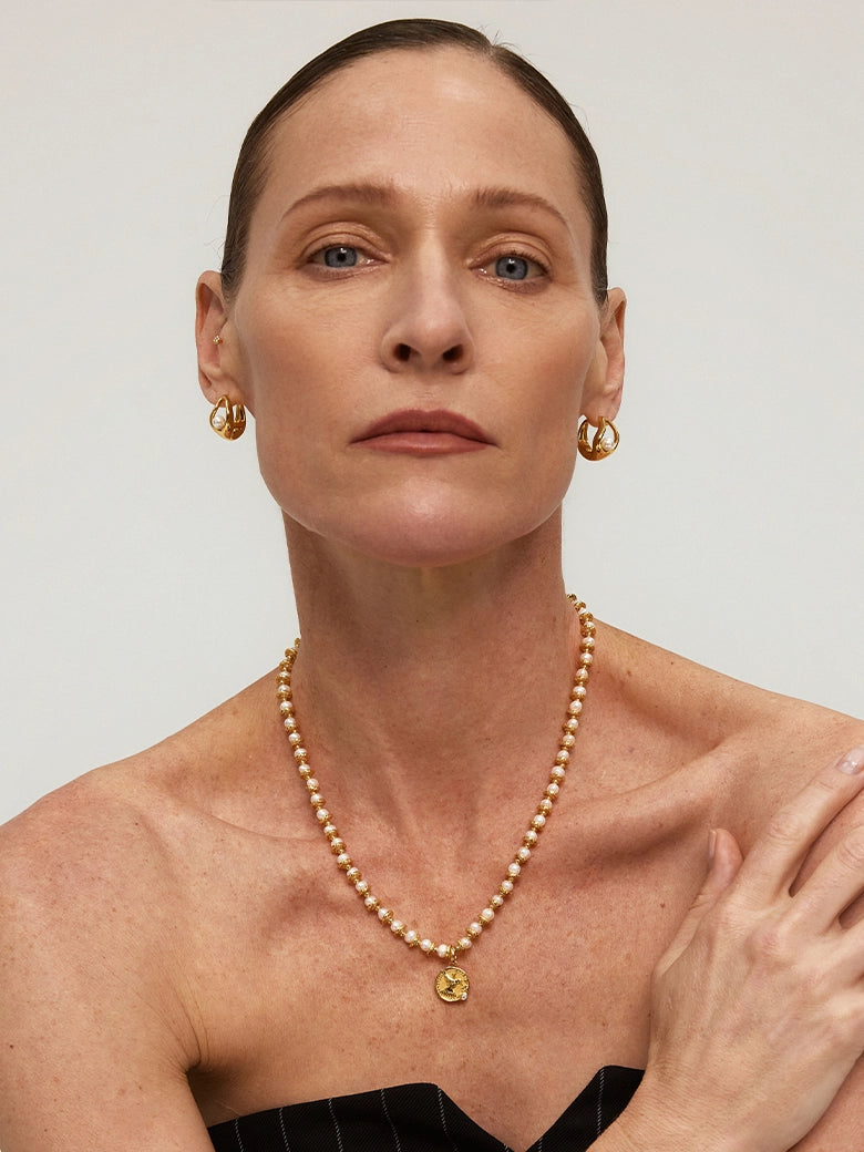 Close-up of a woman's neck showcasing Diamond Dove Coin Pearl Necklace
