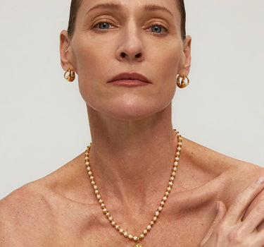 Close-up of a woman's neck showcasing Diamond Dove Coin Pearl Necklace