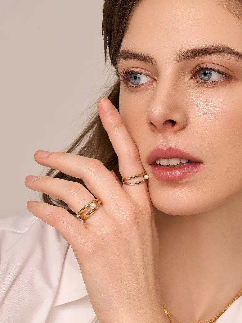 Close-up of a woman's finger showcasing Double Hoop Pearl Stacking Ring