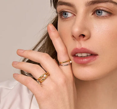 Close-up of a woman's finger showcasing Double Hoop Pearl Stacking Ring