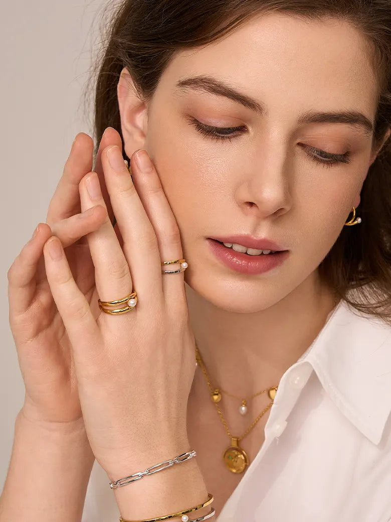 Close-up of a woman's finger showcasing Double Hoop Pearl Stacking Ring