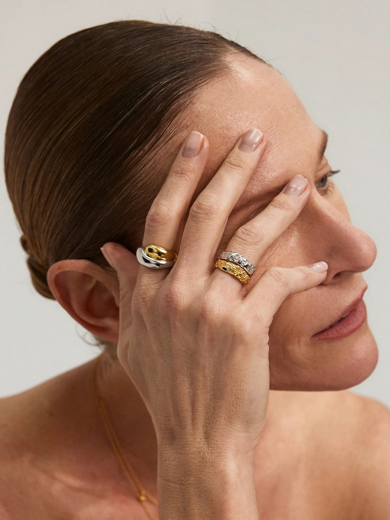 Close-up of a hand wearing the Duo Dome Ring alongside other rings, showcasing a minimalist jewelry aesthetic.