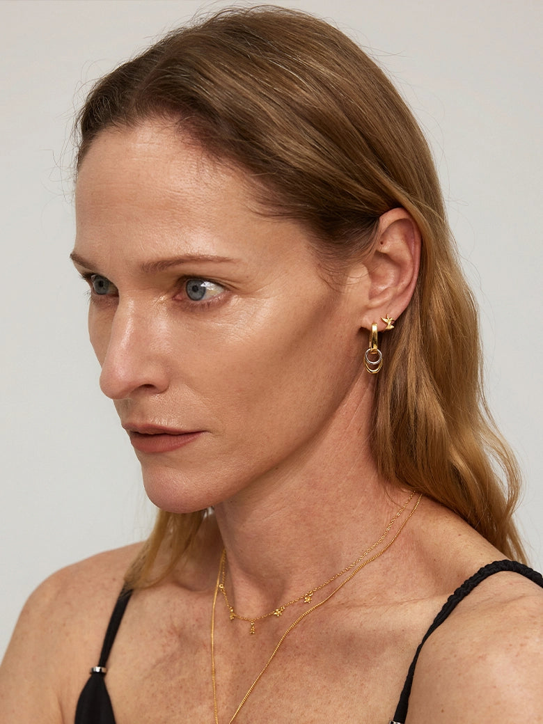 Close-up of a model wearing Duo Link Hoop Earrings, showcasing their two-tone and detachable design.