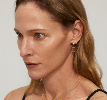 Close-up of a model wearing Duo Link Hoop Earrings, showcasing their two-tone and detachable design.