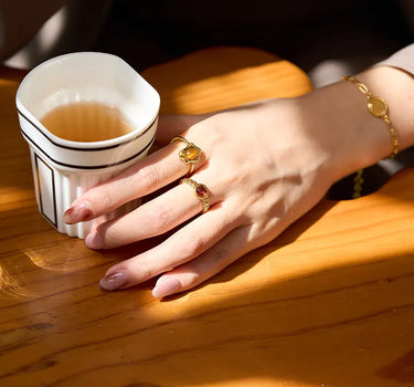 Close-up of a woman's finger showcasing Garnet Open Ring