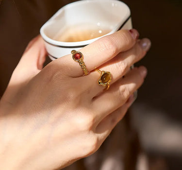 Close-up of a woman's finger showcasing Garnet Open Ring