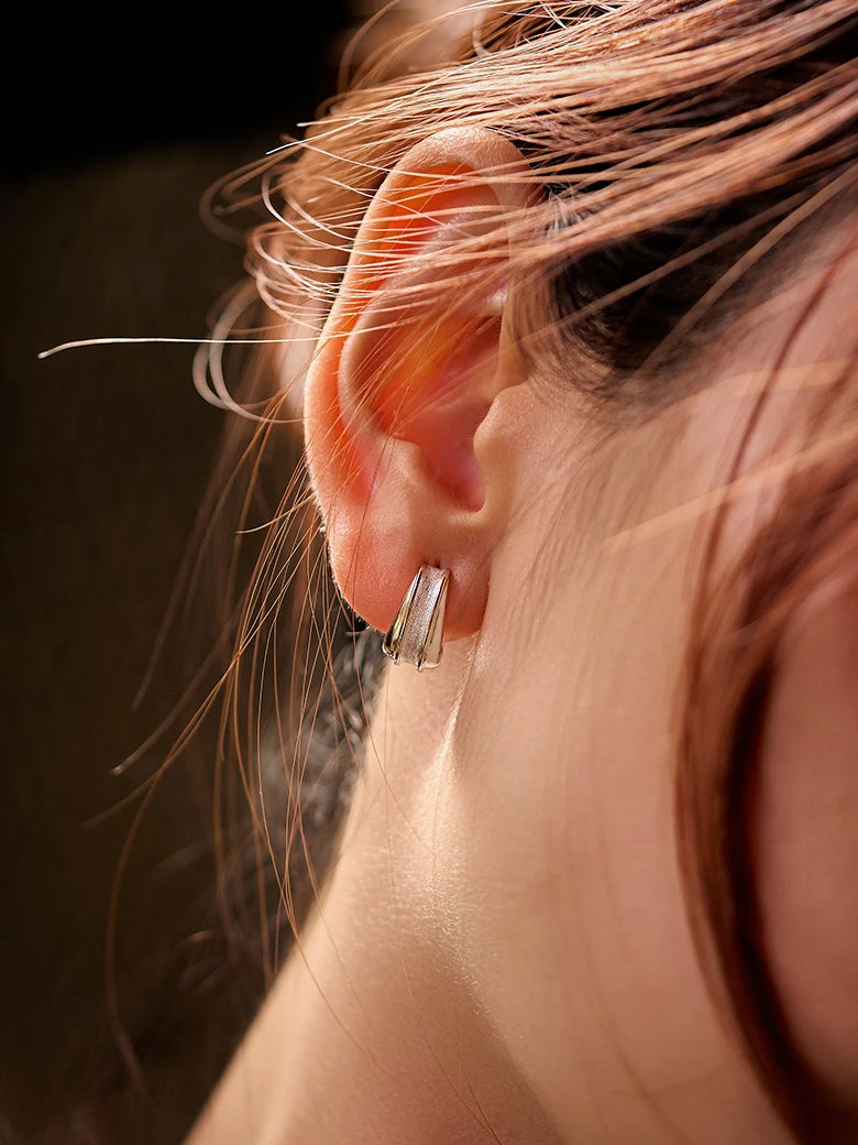 Close-up of a woman's ear showcasing Geometric Silver Stud Earrings