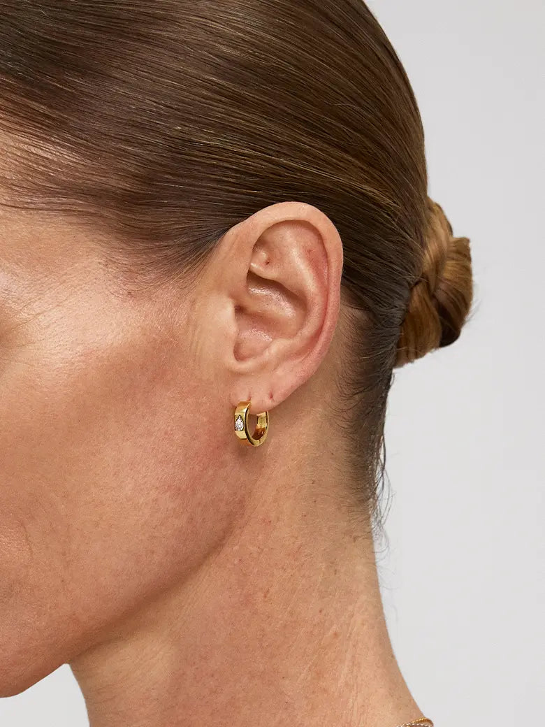 Close-up of a woman's ear showcasing Halo Diamond Hoop Earrings