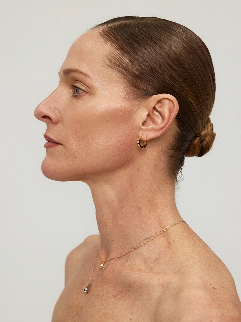 Close-up of a woman's ear showcasing Halo Diamond Hoop Earrings