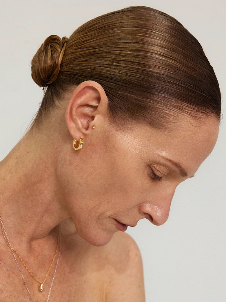 Close-up of a woman's ear showcasing Halo Diamond Hoop Earrings