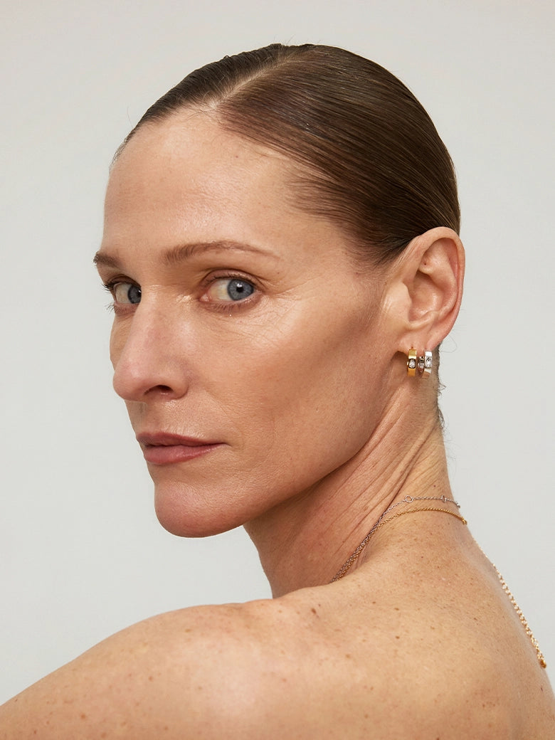 Close-up of a woman's ear showcasing Halo Diamond Silver Hoop Earrings