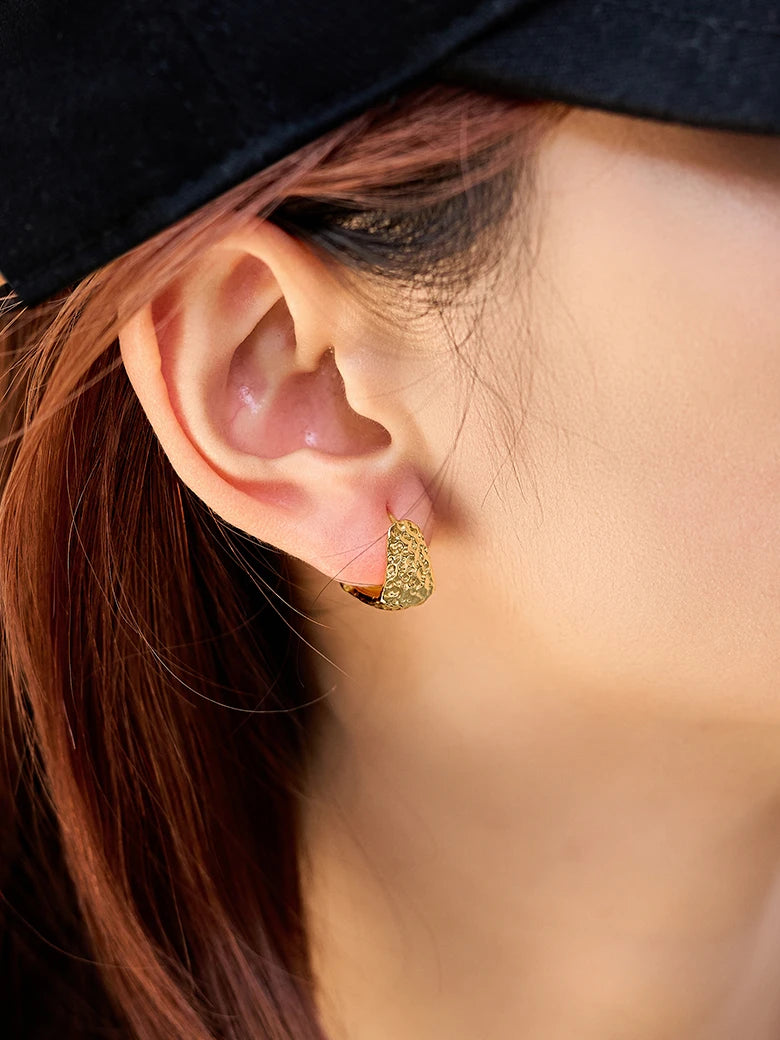 Close-up of a woman's ear showcasing HammeredHoopEarrings