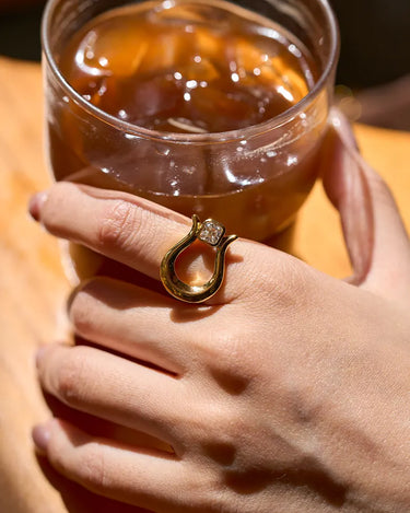 Close-up of a woman's finger showcasing Lyre Moissanite Ring