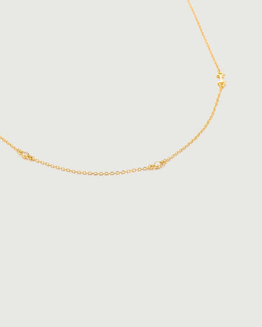 Mini Diamond Bezel Necklace featuring a delicate gold chain with bezel-set diamonds accenting the design.