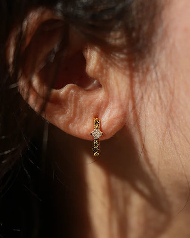 Close-up of a woman's ear showcasing Moissanite Braid Huggie Earrings