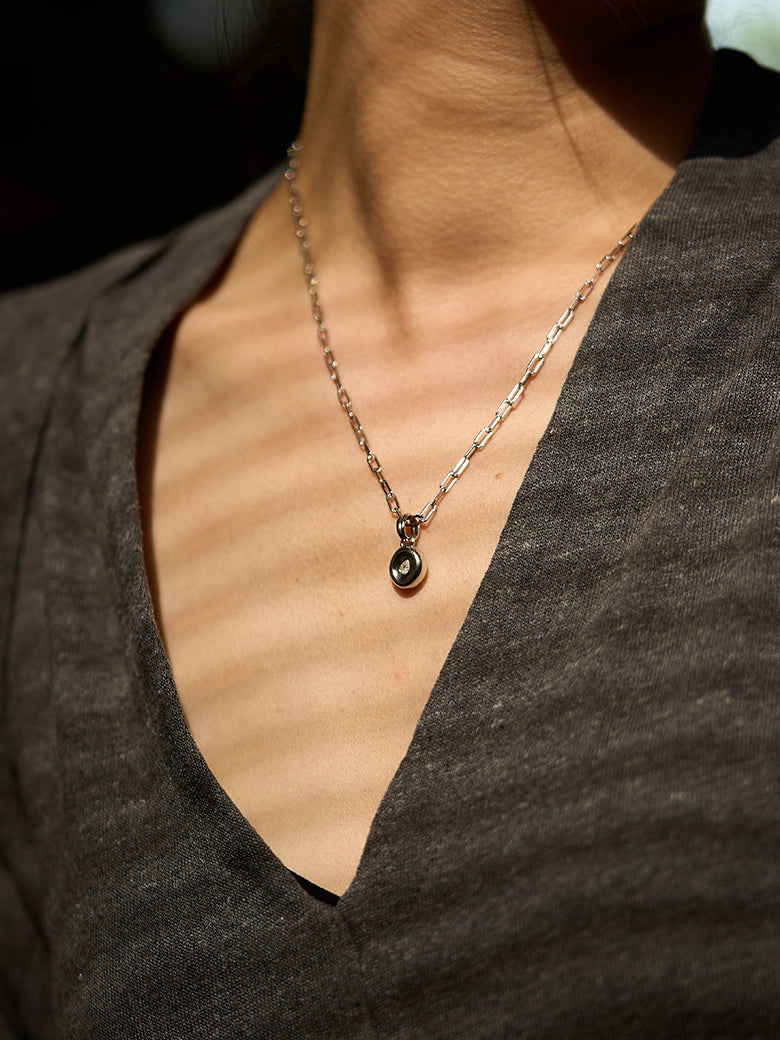 Pear Dome Silver Pendant Necklace featuring a domed pendant on a stylish paperclip chain worn by a model.