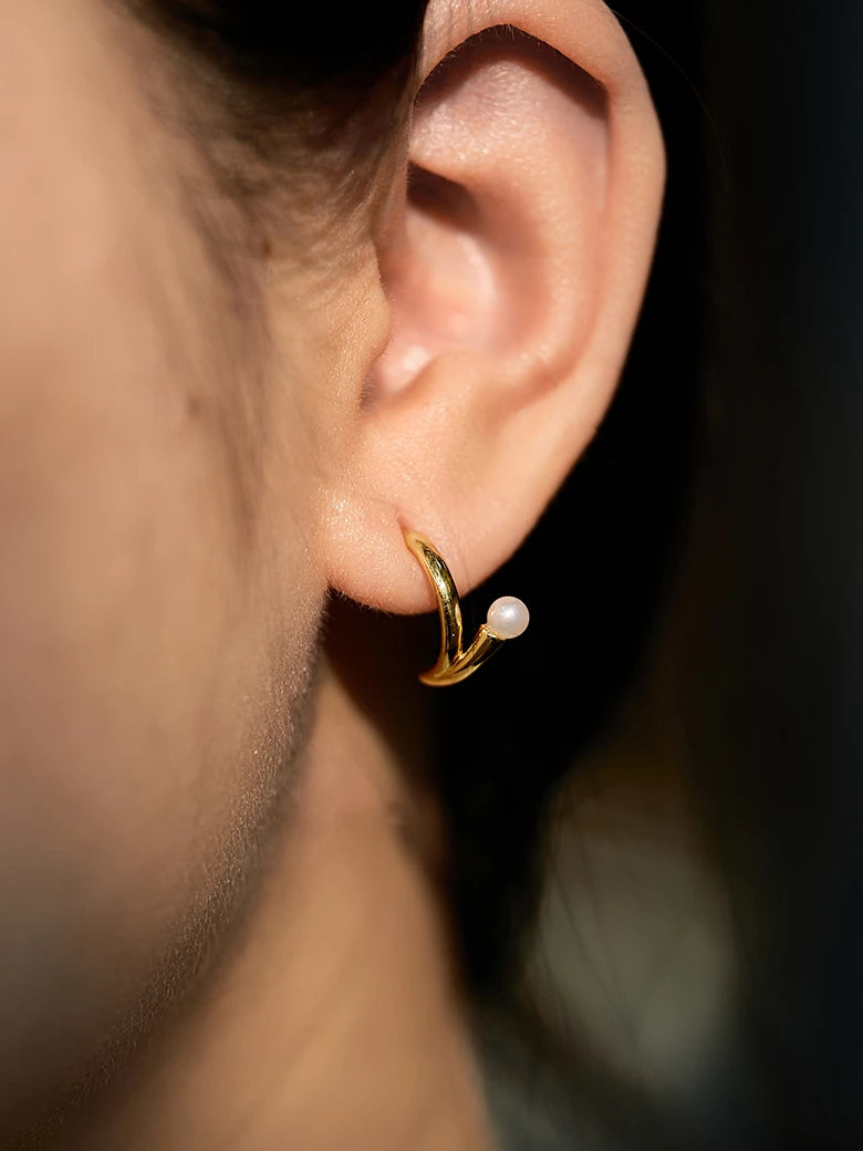 Close-up of a woman's ear showcasing PearlArcEarrings