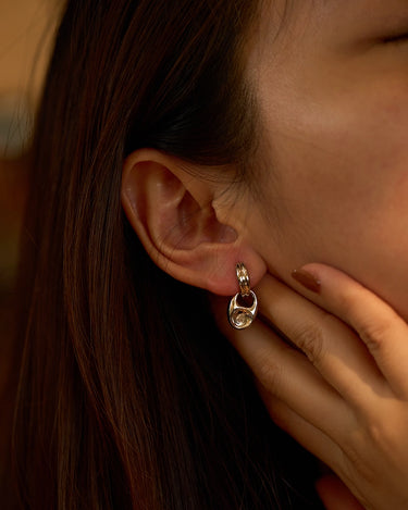 Pebble Solitaire Drops Silver Earrings worn by a woman, showcasing the elegant design and versatility.