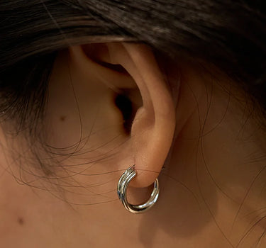 Close-up of a woman's ear showcasing SilverDoubleHoopEarrings