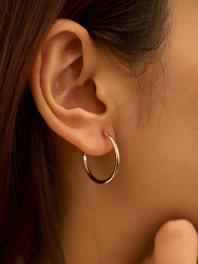 Close-up of a woman's ear showcasing SilverLargeHoopEarrings_1