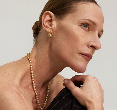 Close-up of a woman's ear showcasing Teardrop Hollow Pearl Hoop Earrings