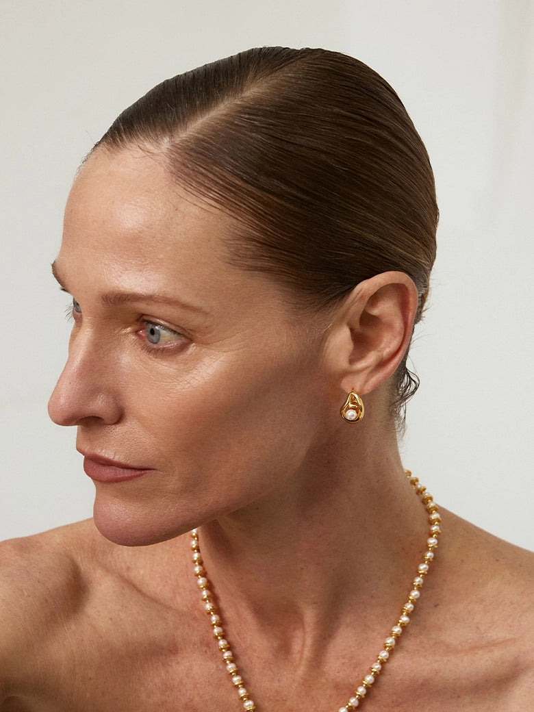 Close-up of a woman's ear showcasing Teardrop Hollow Pearl Hoop Earrings