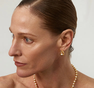 Close-up of a woman's ear showcasing Teardrop Hollow Pearl Hoop Earrings