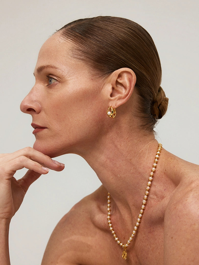 Close-up of a woman's ear showcasing Teardrop Hollow Pearl Hoop Earrings