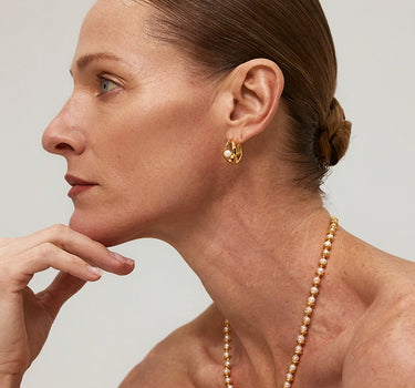 Close-up of a woman's ear showcasing Teardrop Hollow Pearl Hoop Earrings