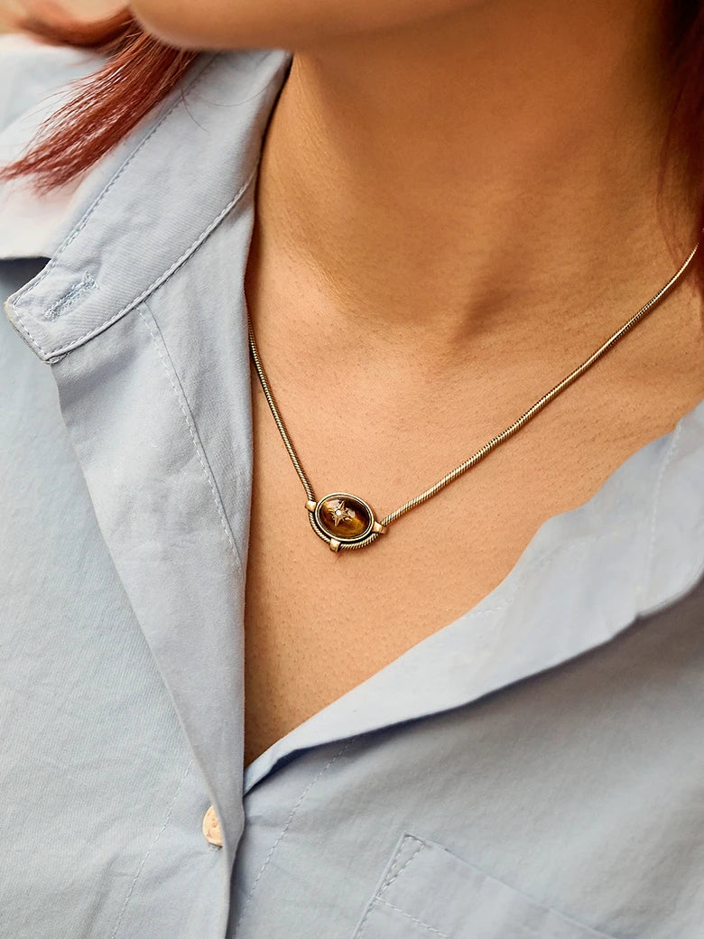 Close-up of a woman's neck showcasing Tiger Eye Signature Charm NecklaceTigerEyeSignatureCharmNecklace