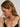 Close-up of a woman's ear showcasing Tiger_sEyeDuoHoopSilverEarrings
