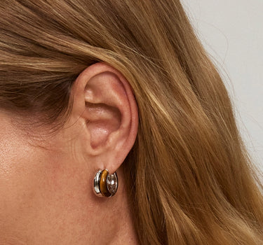 Close-up of a woman's ear showcasing Tiger_sEyeDuoHoopSilverEarrings