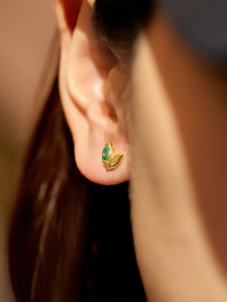 Close-up of a woman's ear showcasingWheatEmeraldAsymmetricEarrings